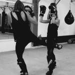 Zwei Frauen. welche gemeinsam Kickboxübungen ausführen.